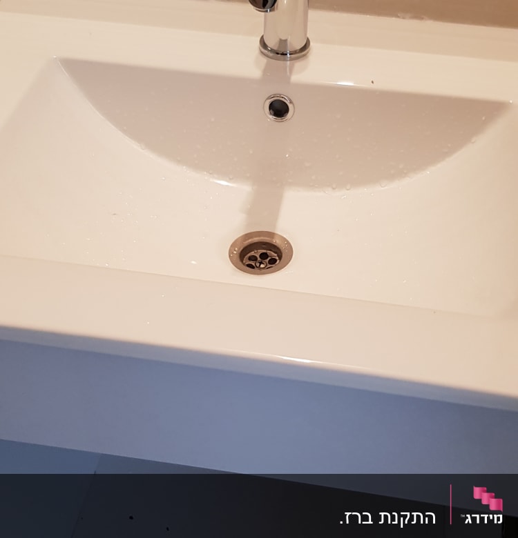 כיור עם ברז כרום פתוח וארון מתחת